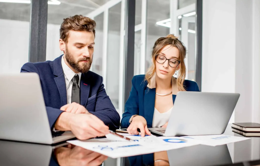 Business professionals reviewing relocation budget documents during corporate relocation vs corporate housing planning