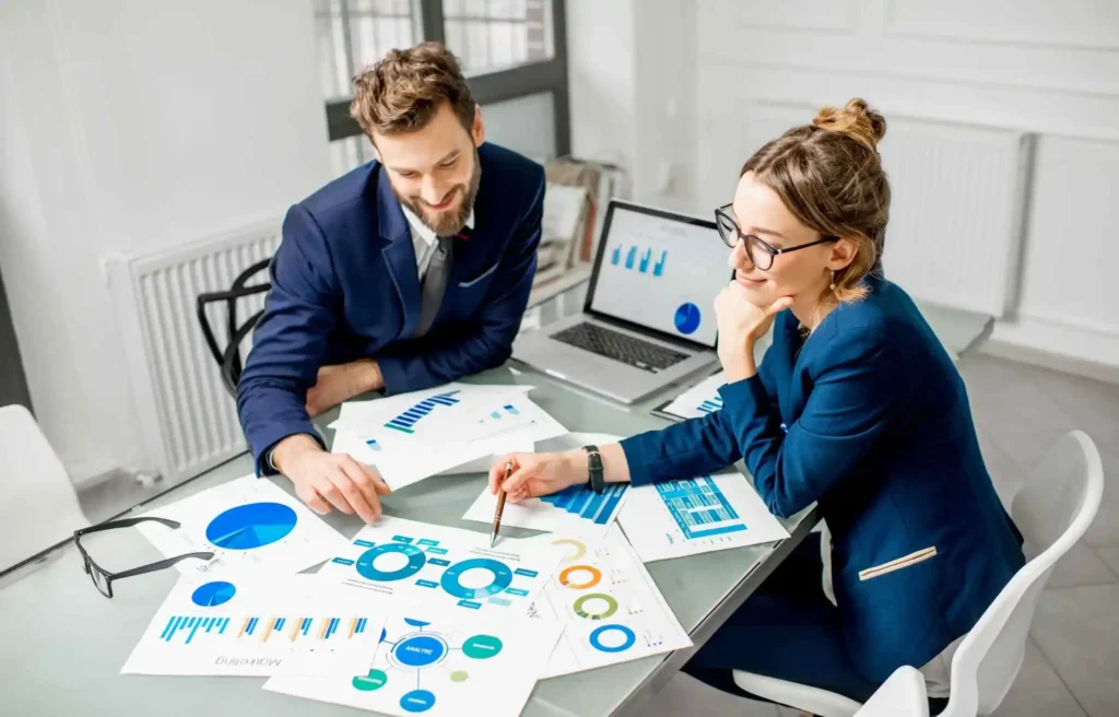 Business team analyzing corporate relocation statistics and housing migration data in office meeting.