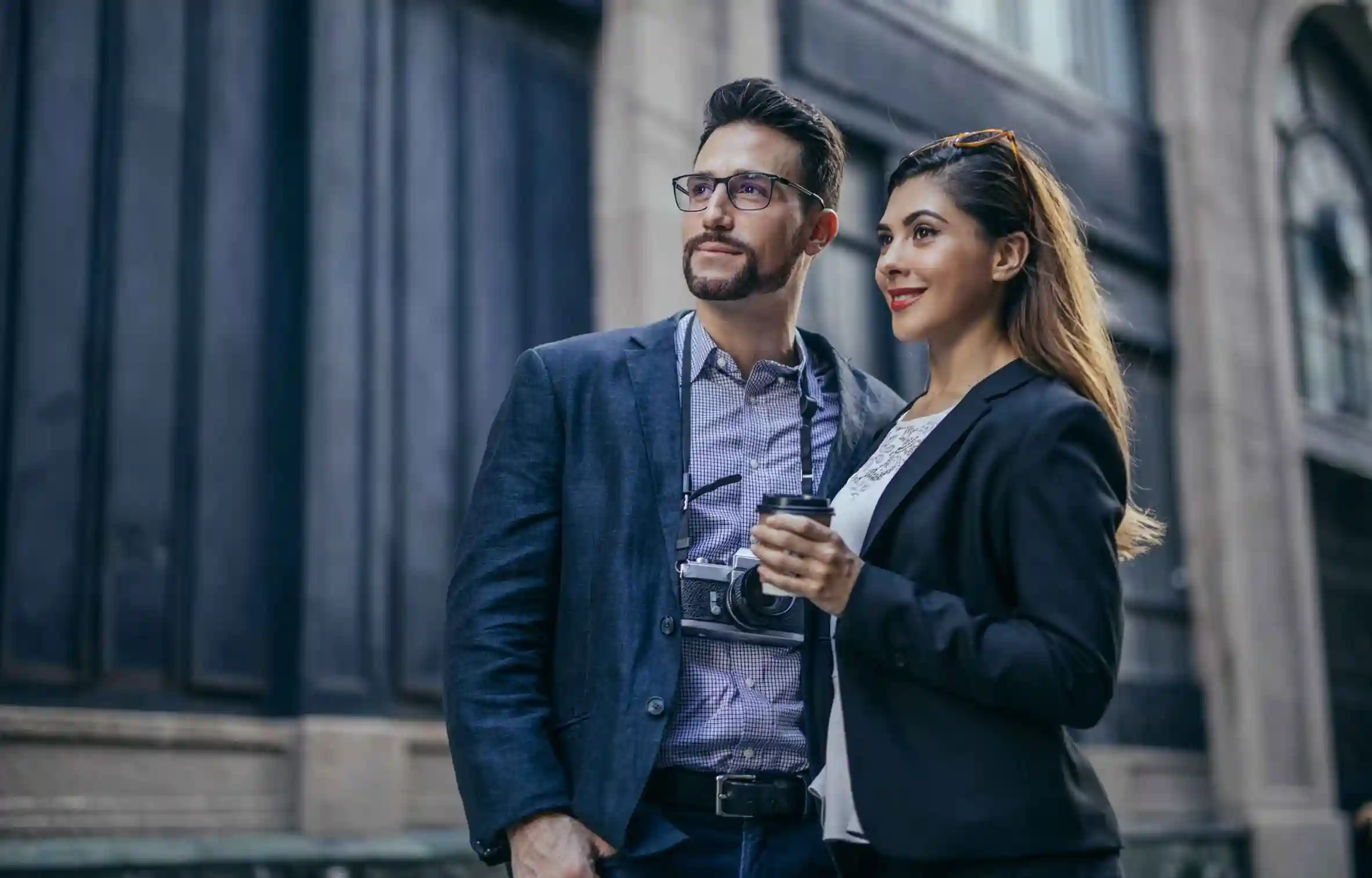 Well-dressed couple looking ahead on a city street, capturing moments during a city walk.