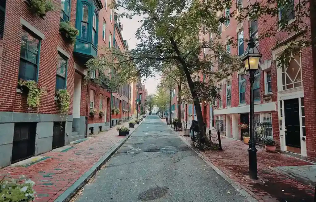 Boston historic brick street lined with trees and classic brownstones, reflecting one of the best places for teachers to move.