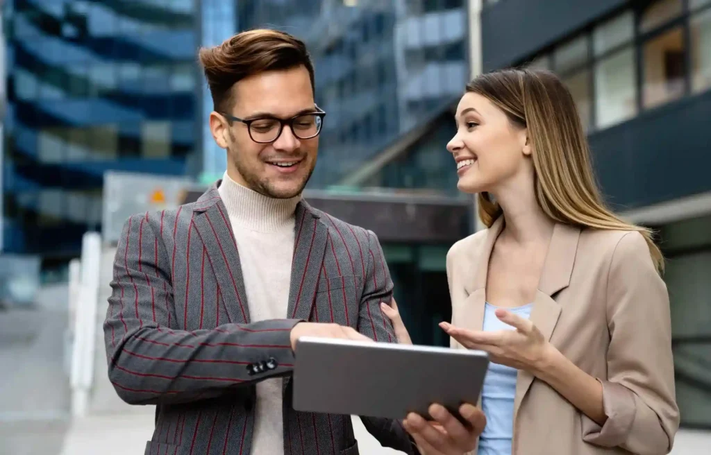 Corporate professionals reviewing relocation data on tablet reflecting global mobility trends 2026 and AI driven workforce planning.