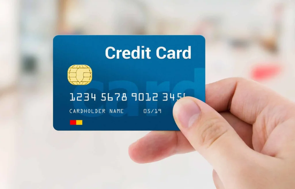 Hand holding credit card representing the best credit cards for moving and managing relocation expenses.