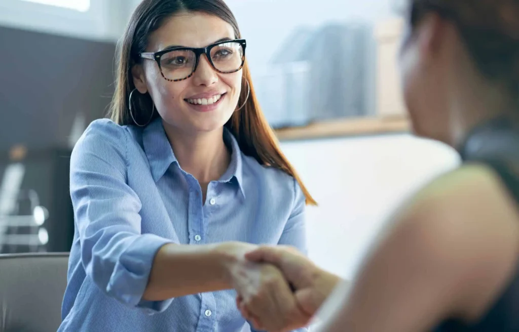 Woman consultant greeting employee during relocation assistance for employees meeting.