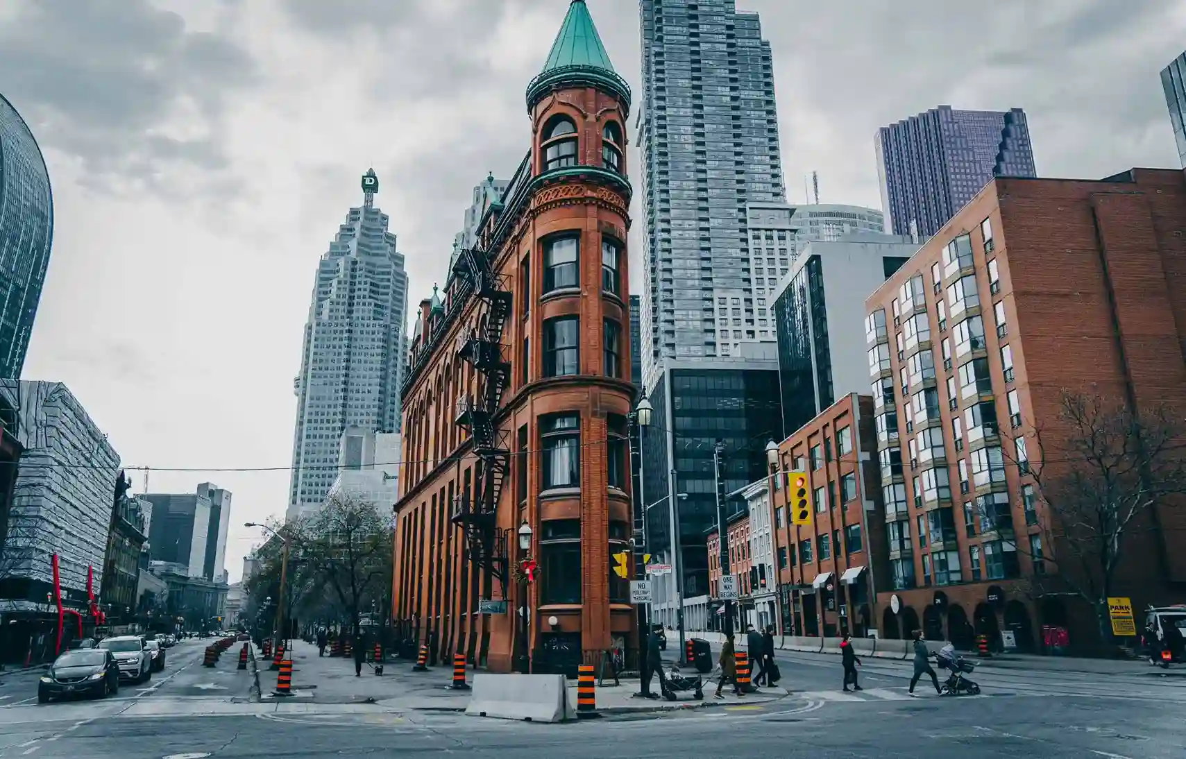 Historic Gooderham Building in downtown Toronto with modern skyline and street view.