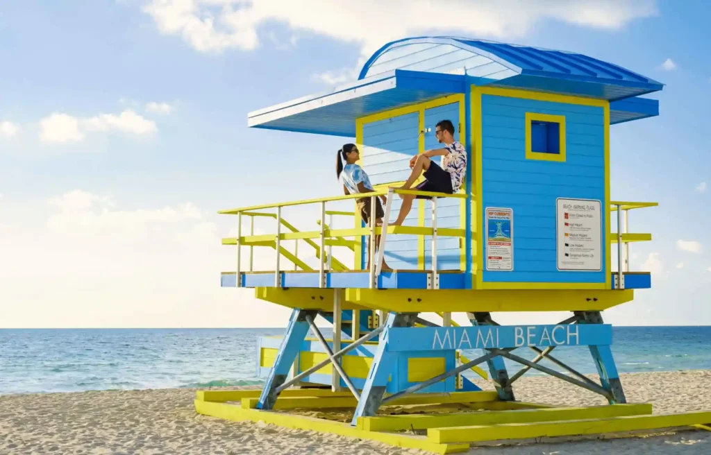 People relaxing on Miami Beach lifeguard tower, reflecting lifestyle after relocation.