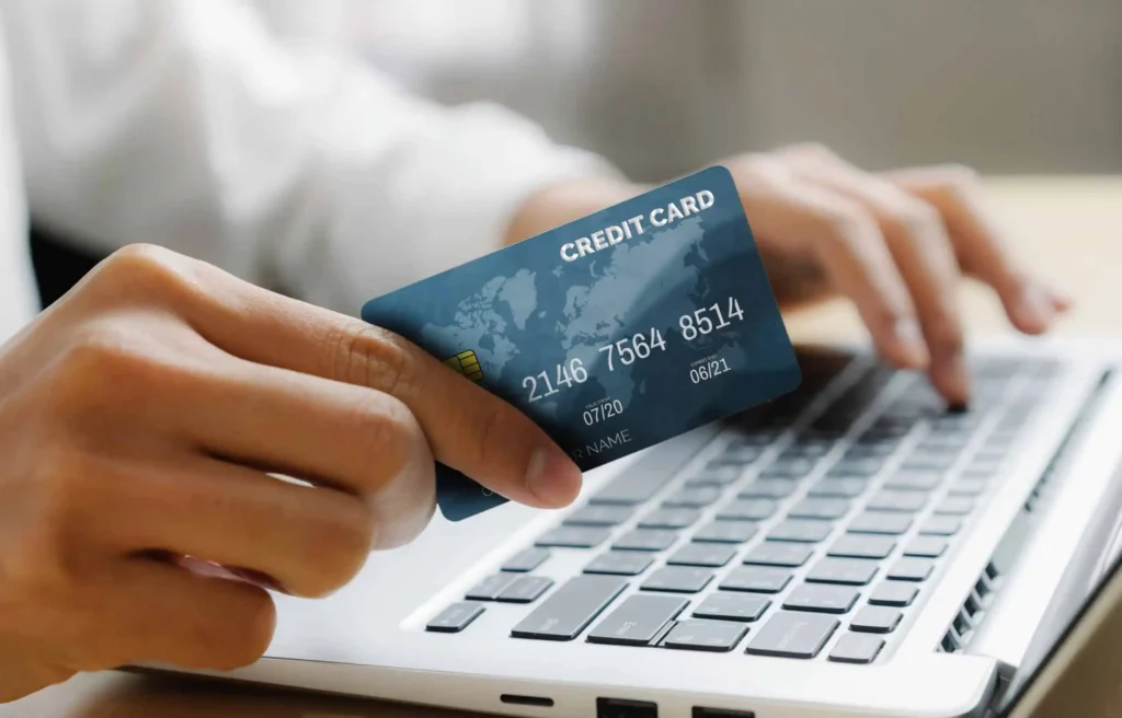 A person holding a credit card while searching for a credit card strategy for digital nomads online.