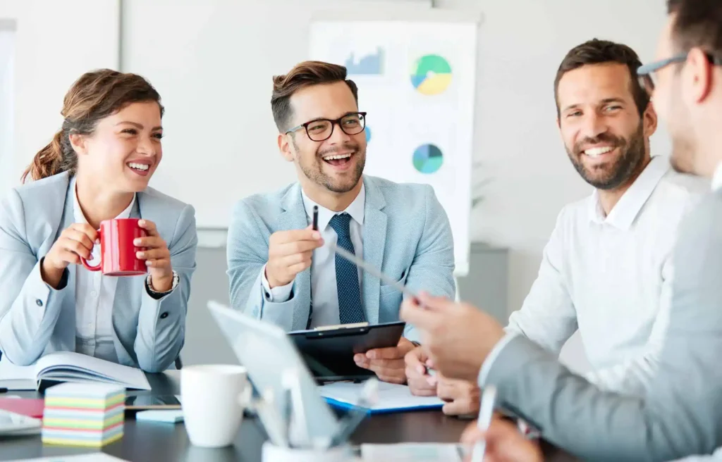 Business team discussing how to gross up relocation reimbursement in a bright office meeting.