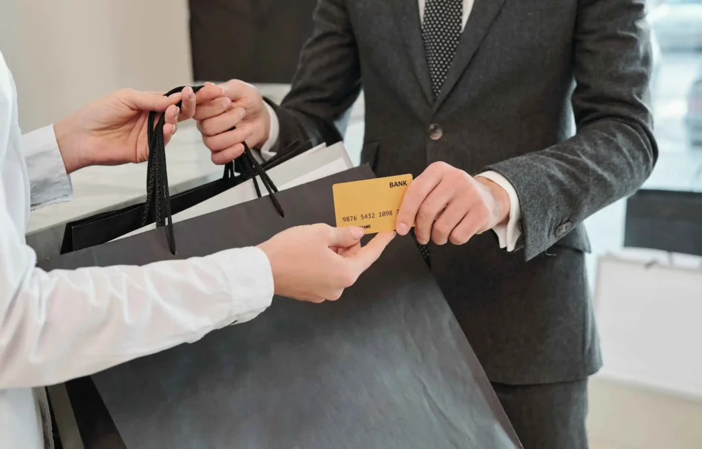 A businessman using the $30,000 credit card hack while receiving shopping bags.