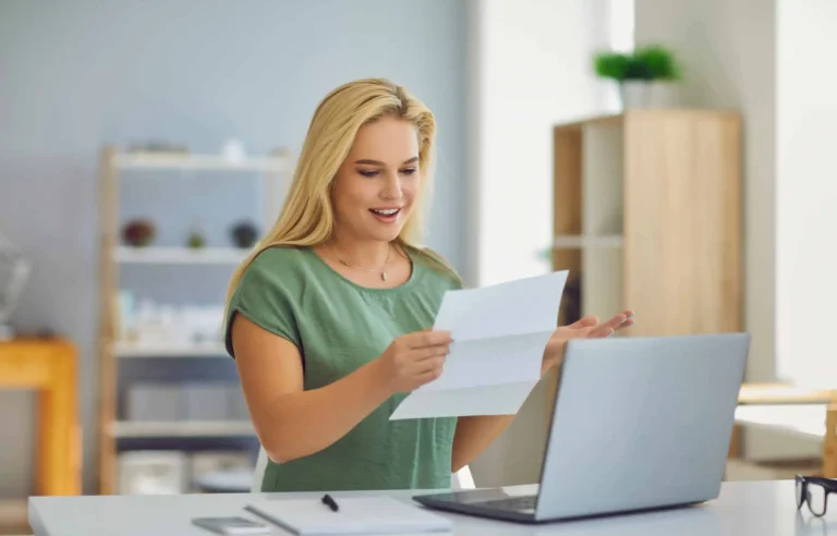 Professional reading an offer letter beside a laptop before accepting a relocation role.