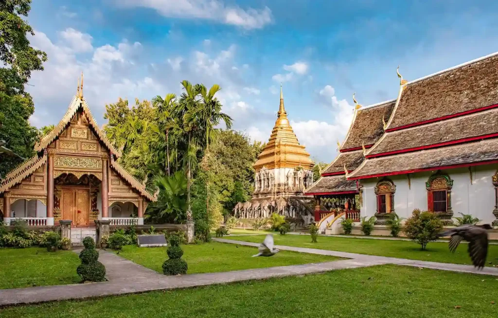 Traditional Thai temple buildings and a golden stupa in Chiang Mai, best cities for digital nomads.