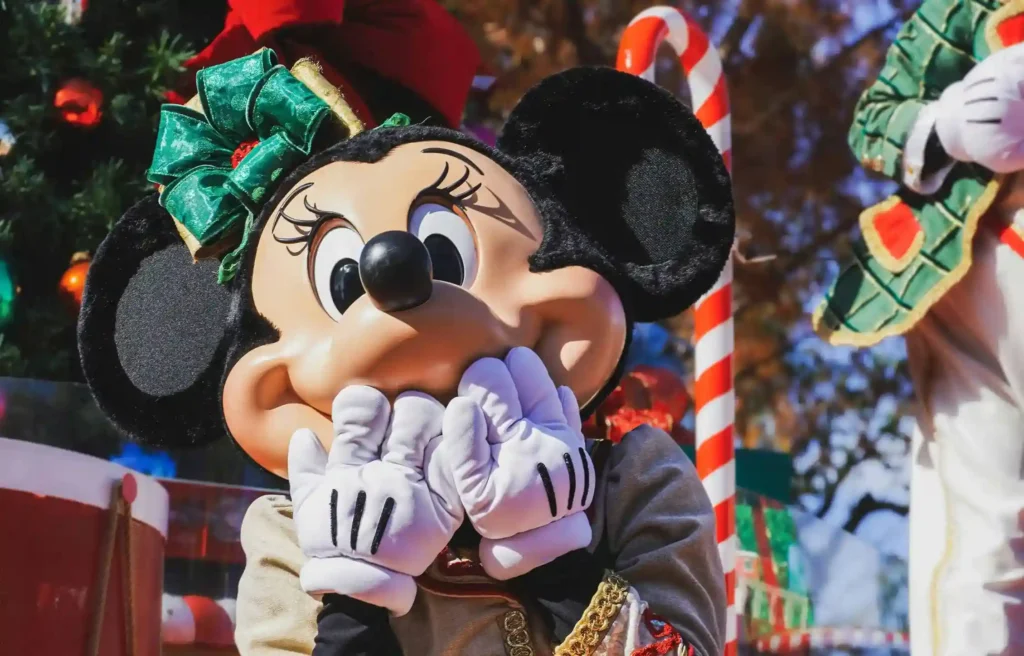 Credit cards for Disney vacations with Minnie Mouse in a holiday dress at the Disneyland Christmas parade.