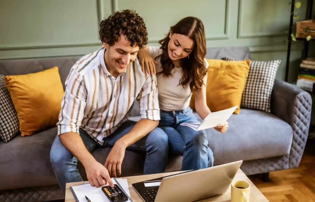 A couple reviewing state tax residency paperwork together on a living room sofa.