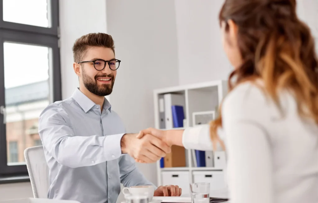 Business professionals shaking hands while discussing moving to Denver.