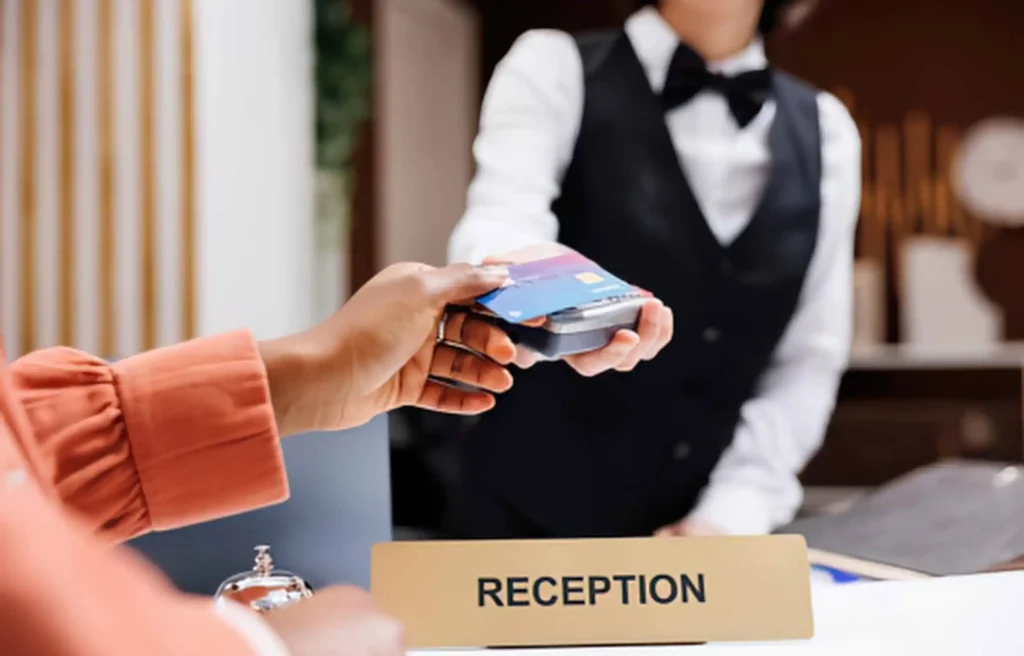 Guest pays by card at a hotel reception; Chase Sapphire Hyatt transfer cut.