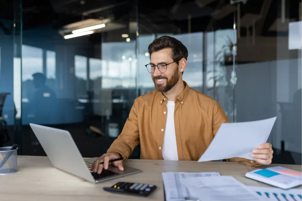 Mobility manager reviewing core-flex relocation policy costs on a laptop in a modern office.