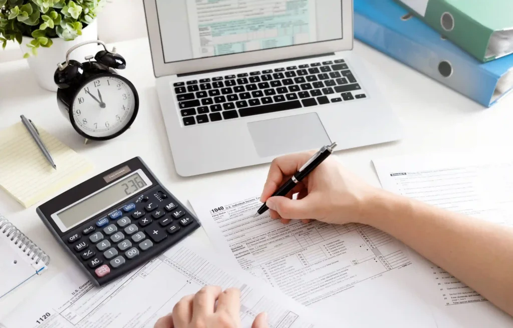 Person calculating temporary housing relocation taxes at a desk.