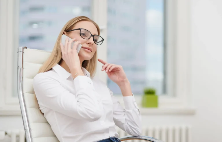 Woman calling a relocation company to discuss moving costs and support from a bright office.