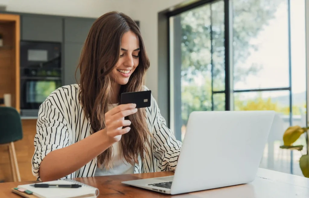 Woman comparing the best bank accounts for expats moving to the US while using a laptop at home.