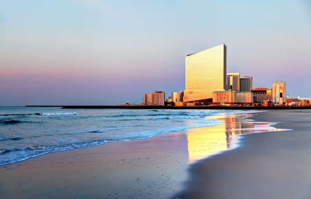 Atlantic City, New Jersey beach and skyline reflecting on the ocean at sunset.