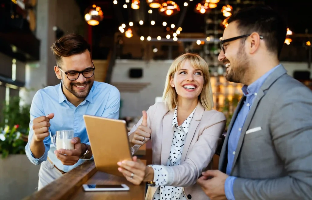 Corporate relocation consultant discussing a move plan with two employees over a tablet.