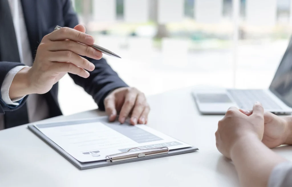 Employer and candidate reviewing a job offer while discussing how to negotiate relocation.