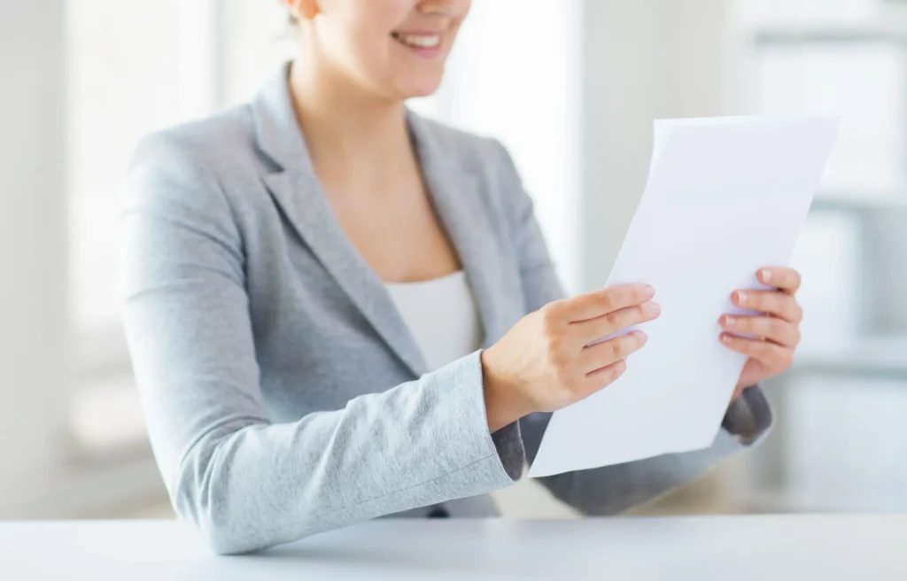 HR professional reviewing a domestic relocation policy vs global mobility policy document in a bright office.