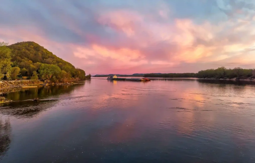 Ocean Springs, Mississippi waterfront and calm coastal water beneath a pink sunset sky.