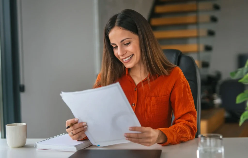 Professional reviewing remote work relocation policy documents at a home office desk.