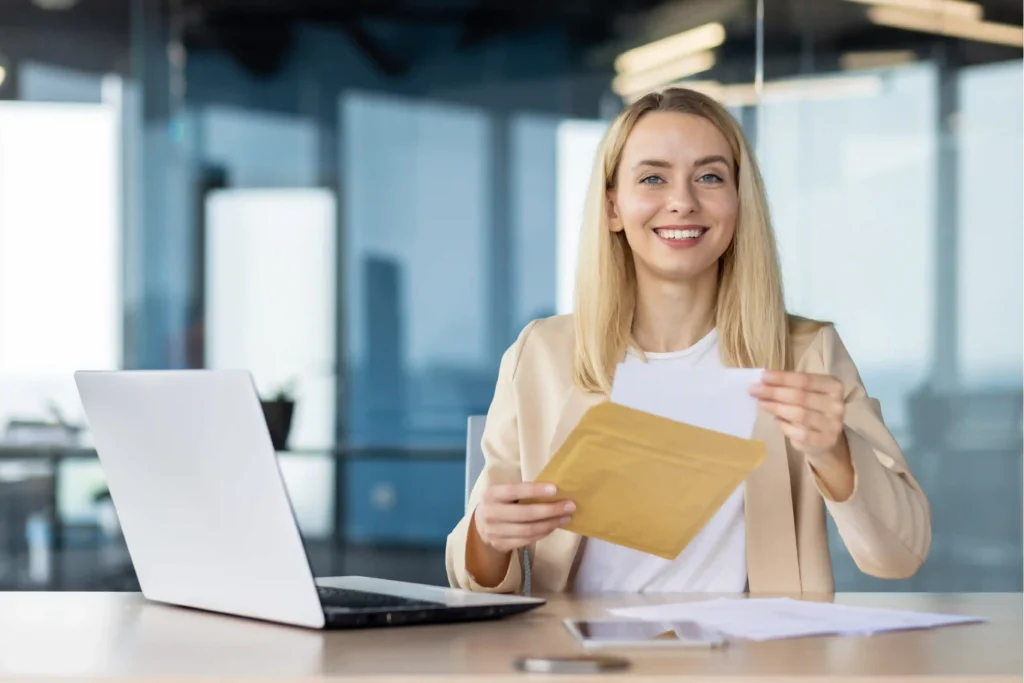 Smiling professional woman reviewing a job offer while preparing to compare two job offers.