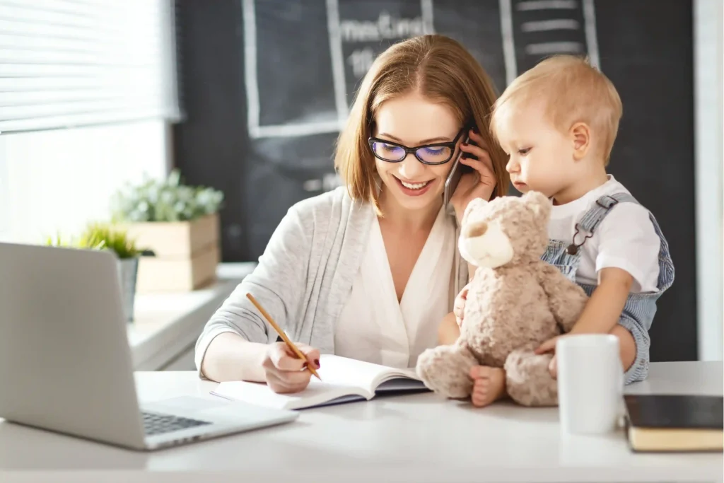Working mother comparing childcare relocation costs while caring for her young child at home.
