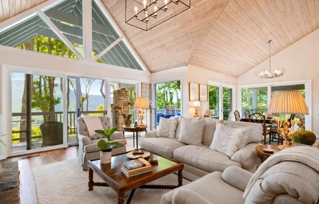 Split family relocation home with bright living room, large windows, white sofas, and mountain views.