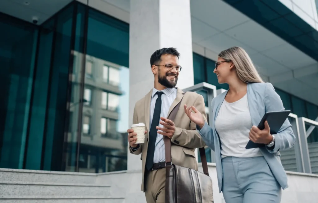 Business professionals discussing geographic mobility and career opportunities outside a modern office building