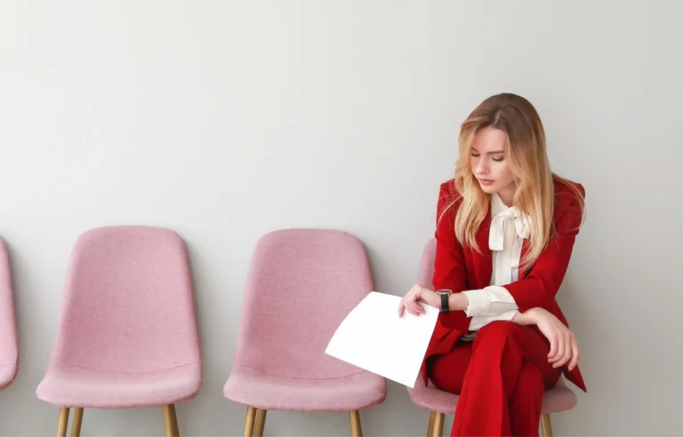 Job seeker waiting for an interview while reviewing a document.