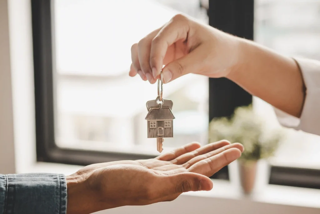 Landlord handing house keys to a new tenant who was able to rent with an offer letter.