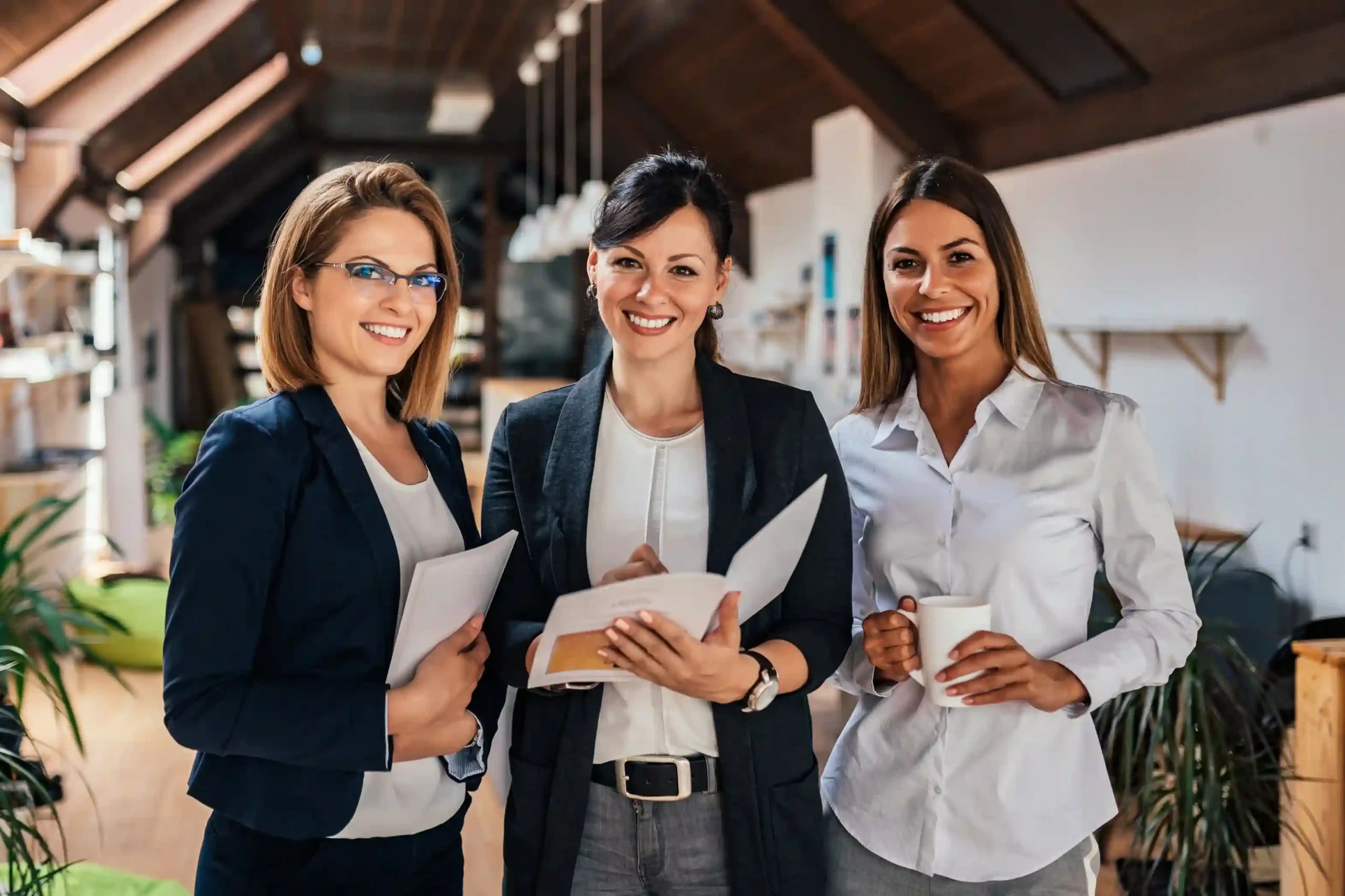 Three professionals reviewing relocation documents together in a modern office.