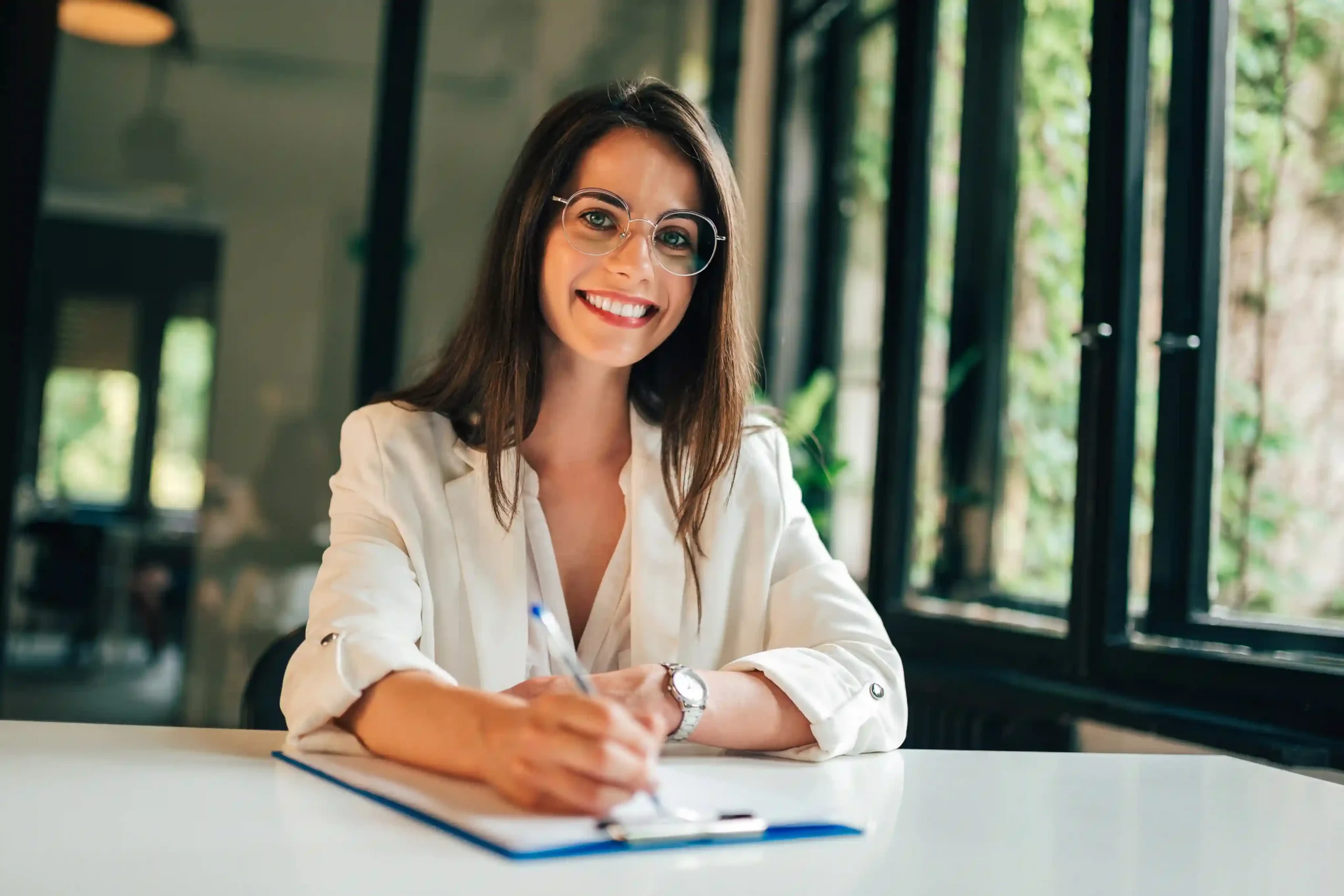 Woman at a desk reviewing relocation documents in a bright modern office.