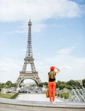 Woman in red trousers posing in front of the Eiffel Tower in Paris