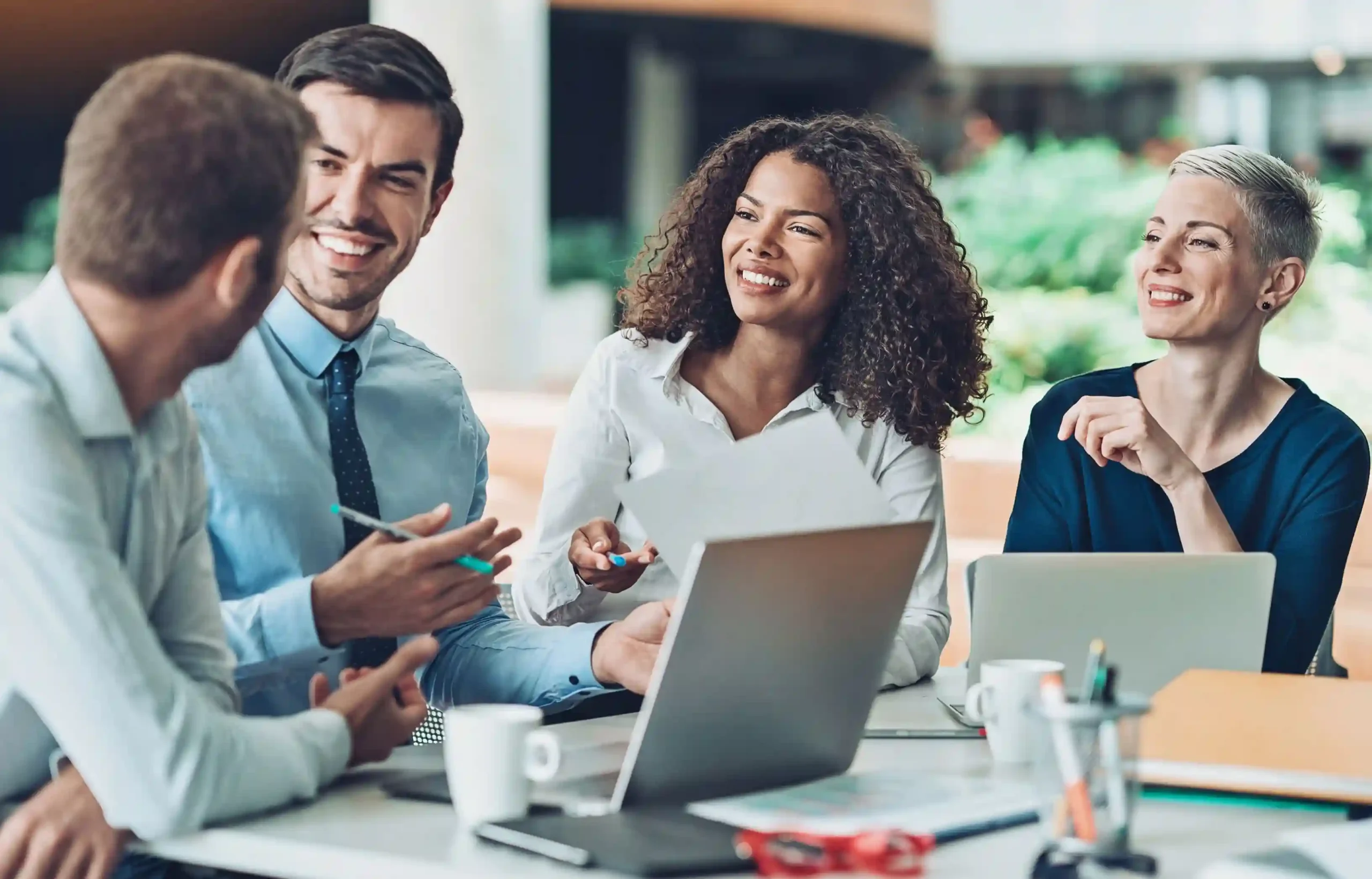 Corporate employees discussing team integration and workforce planning after a merger.