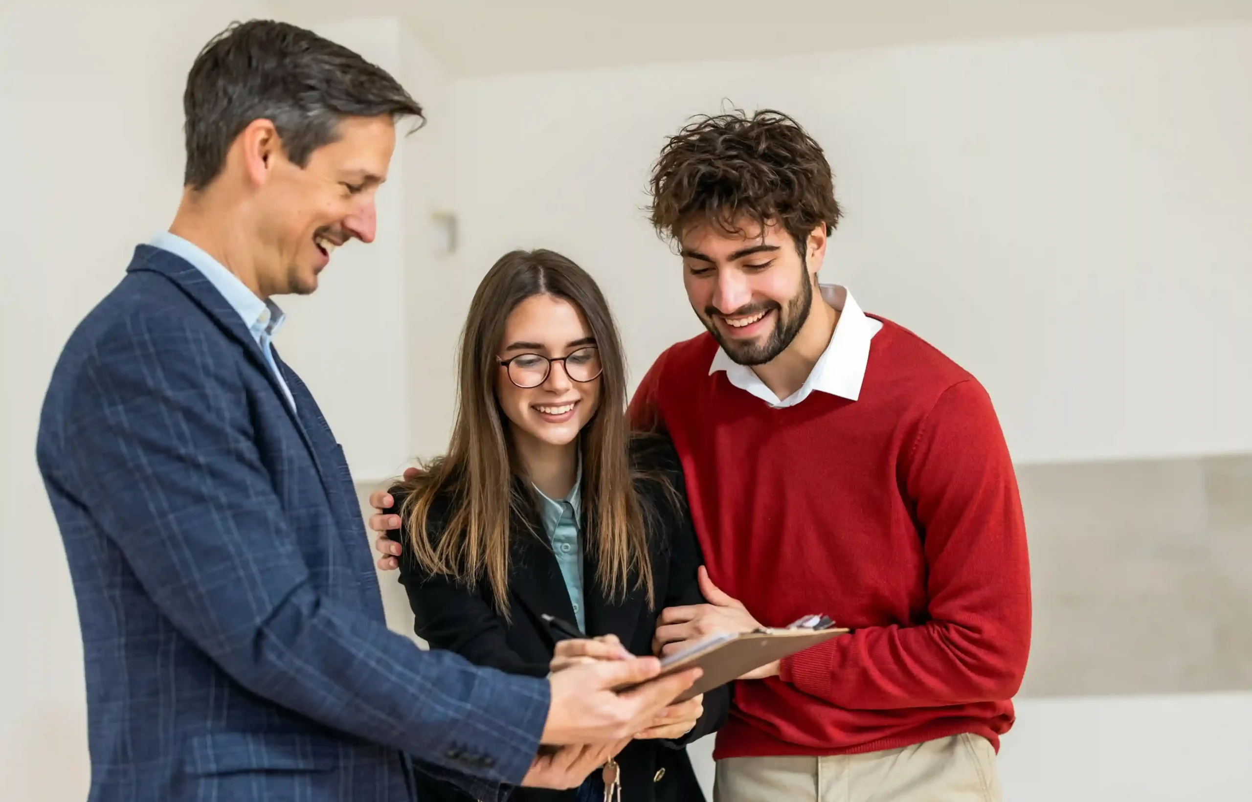 Couple reviewing rental paperwork with a leasing agent before signing an apartment agreement.