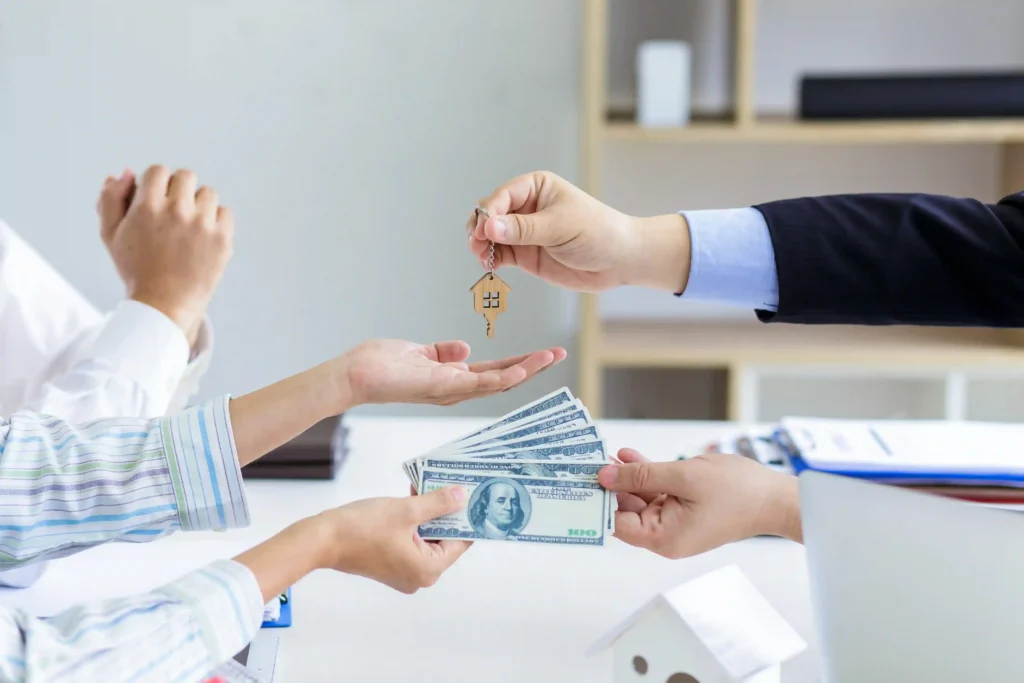 Homebuyer receiving house keys while paying relocation utility deposits during a property transaction.